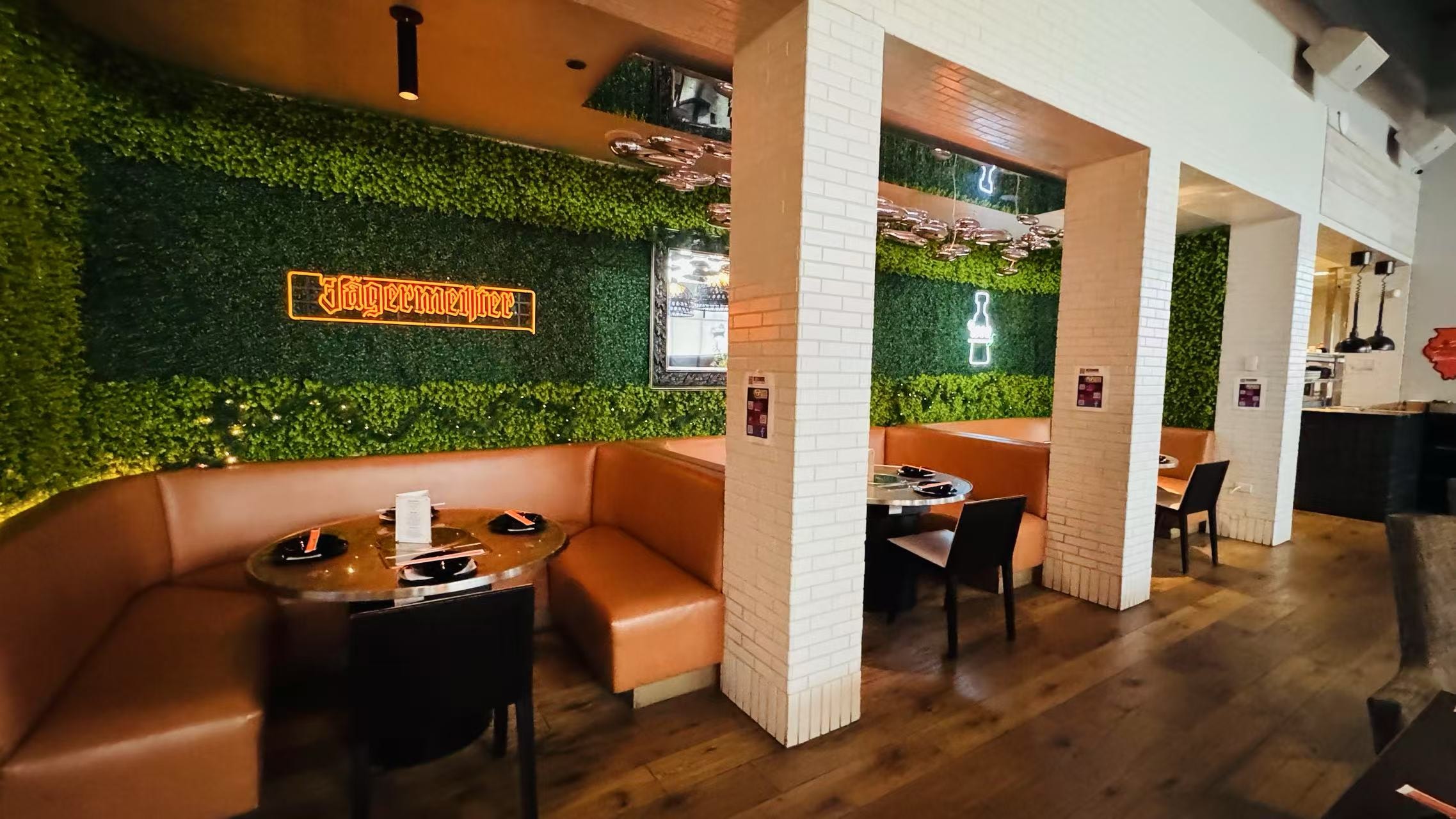 Modern restaurant interior with green walls and bar
